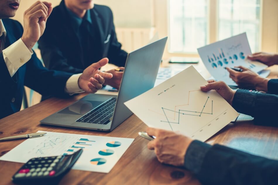 PCと資料を参考に会議をしているイメージ